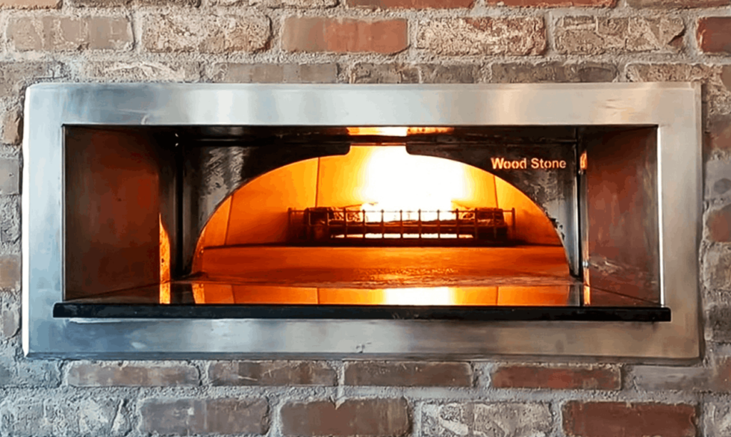 A brick pizza oven, glowing from the inside.